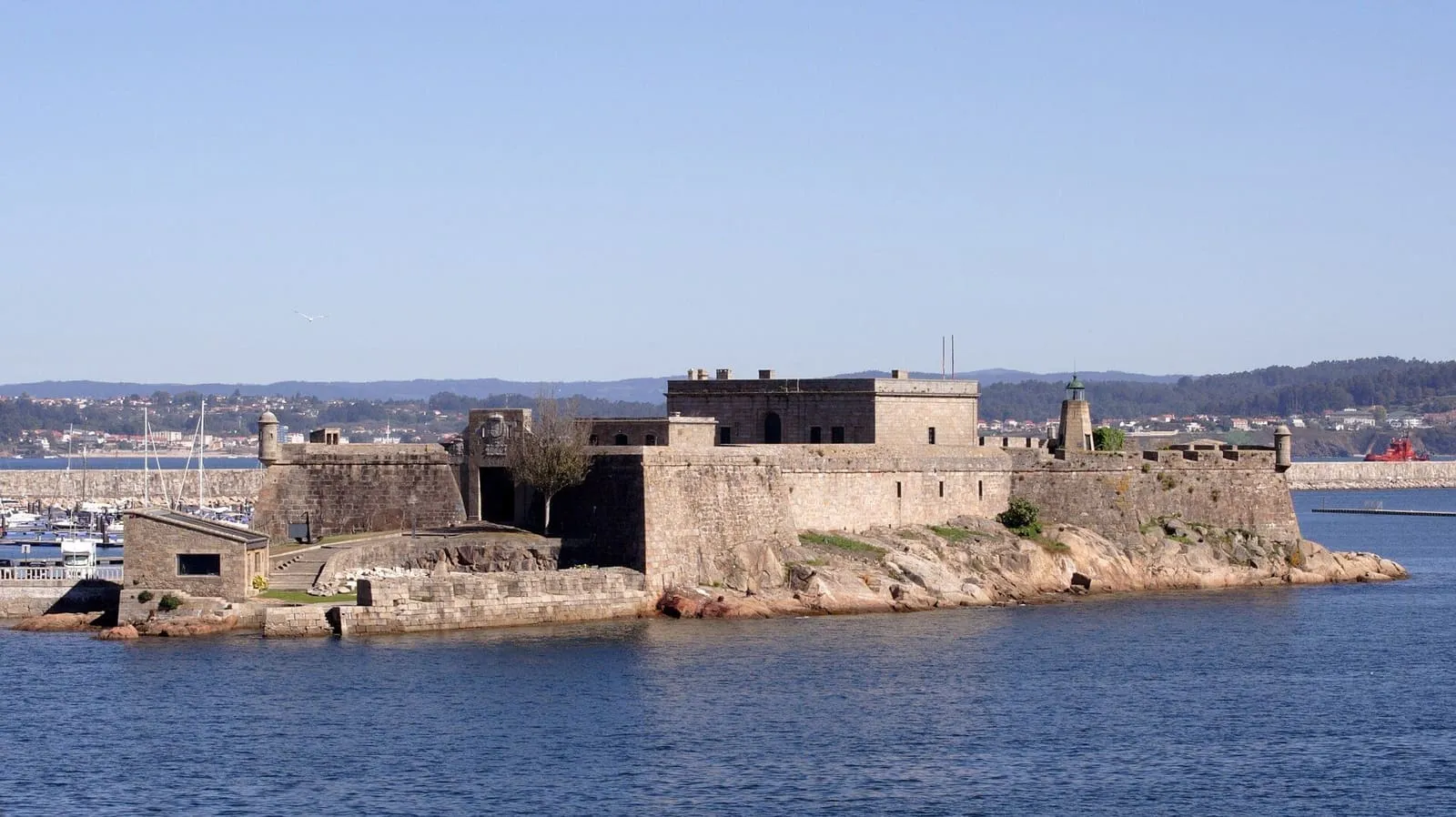 El castillo de San Antón sobre rocas junto al mar, en la bahía de A Coruña