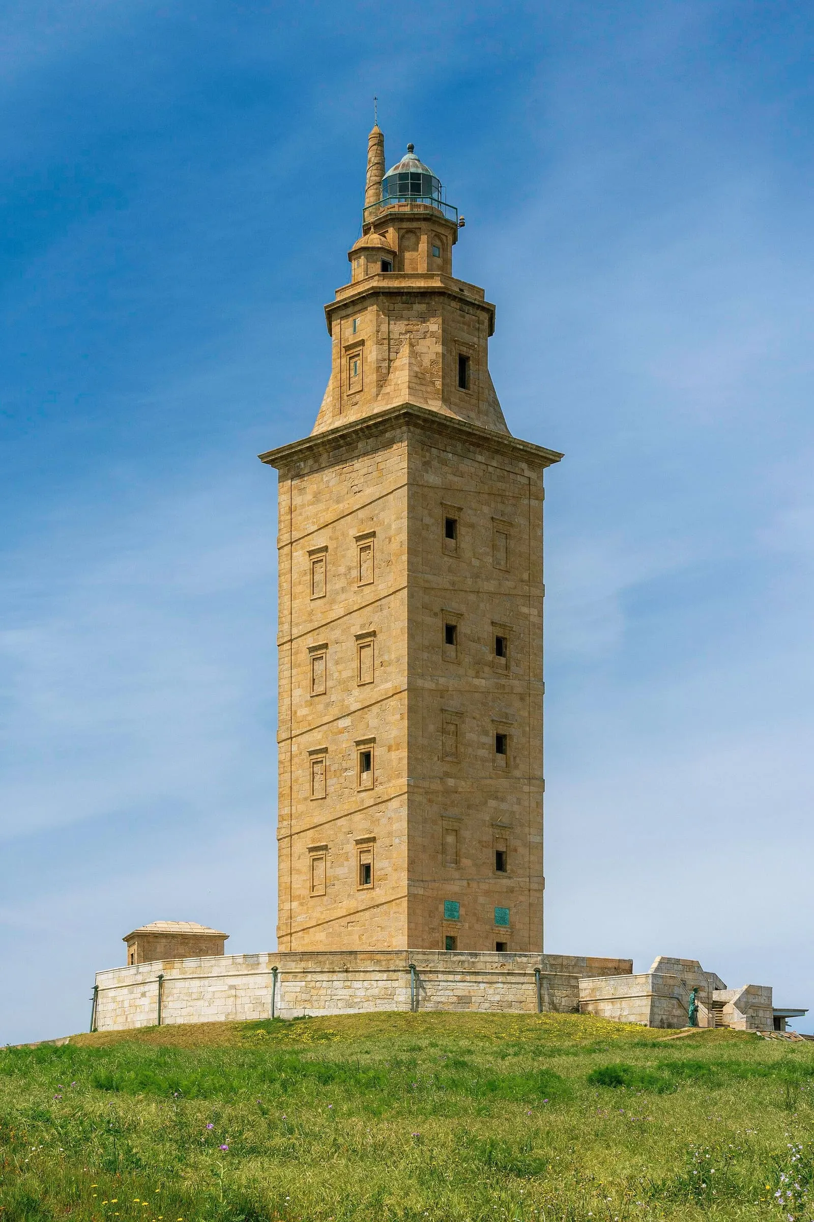 La Torre de Hércules de piedra clara recortada contra el cielo azul