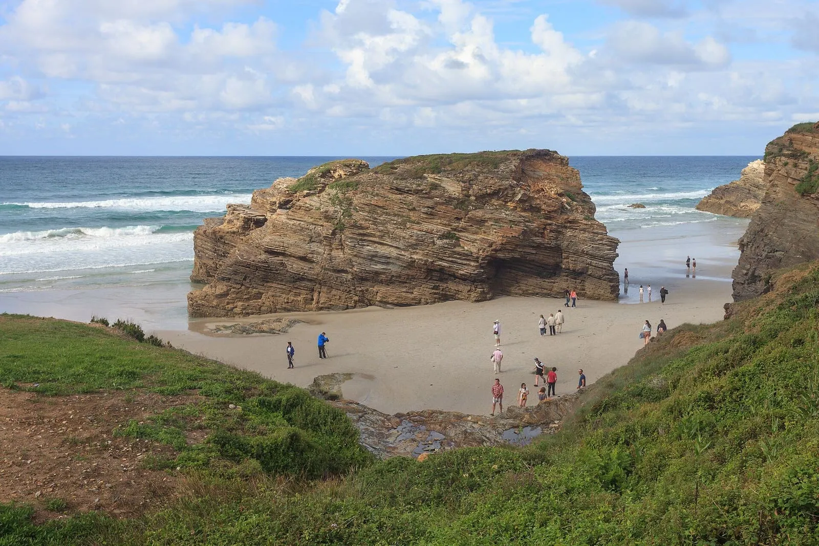 Playa de las Catedrais, con una gran mole de roca sobre la arena y el mar al fondo