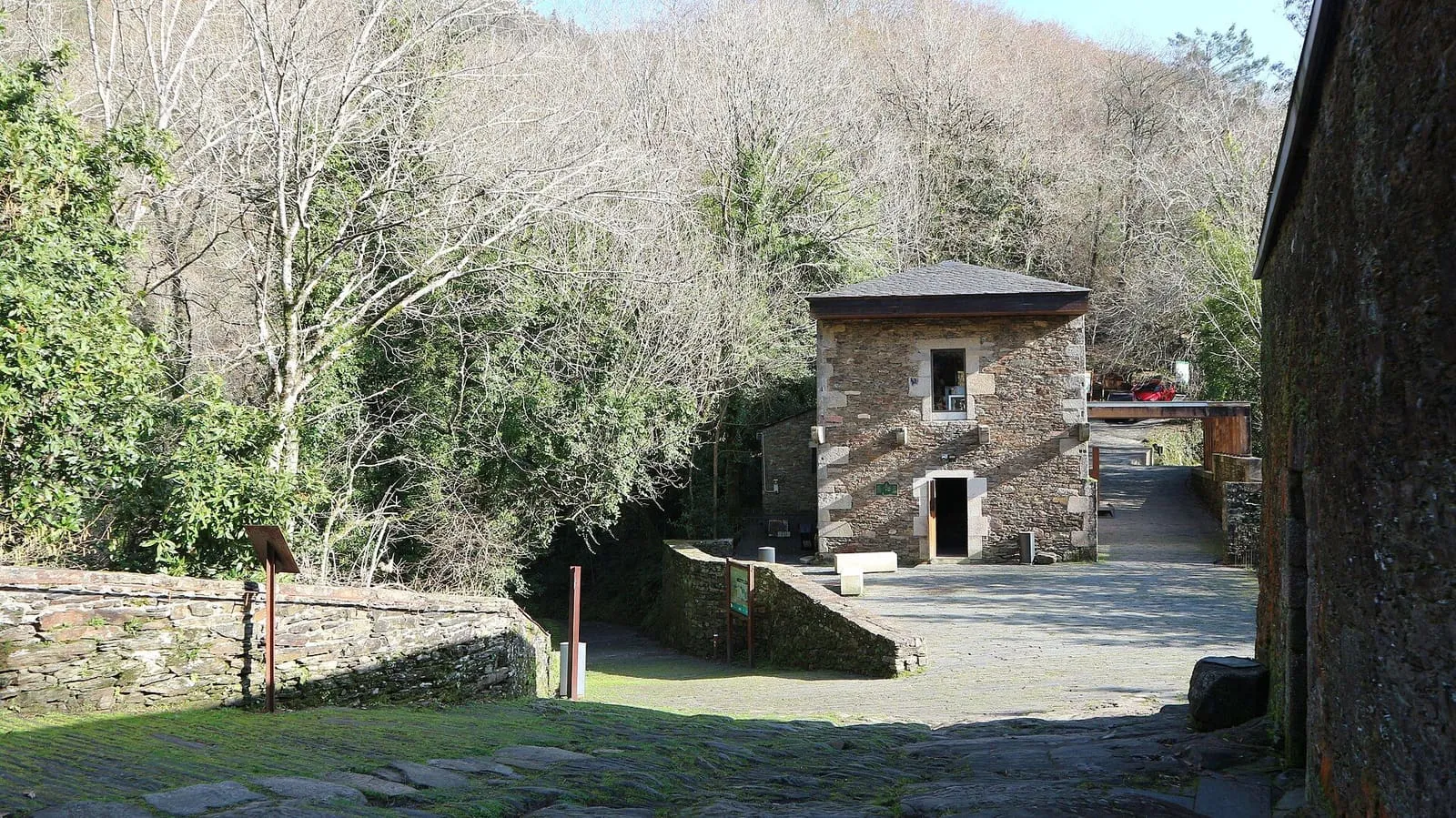 Edificios de piedra del monasterio de Caaveiro entre el arbolado
