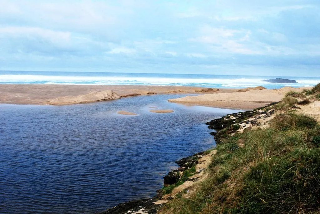 Desembocadura de la laguna de la Frouxeira, con la barra de arena y el mar al fondo