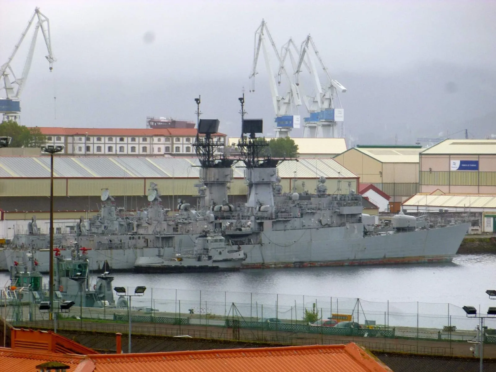 Un buque de guerra en la dársena del Arsenal de Ferrol, con las grúas de los astilleros al fondo