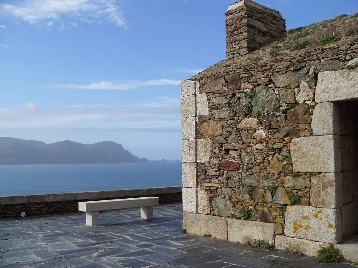 Mirador de piedra con un banco y vistas al mar, en Cabo Ortegal