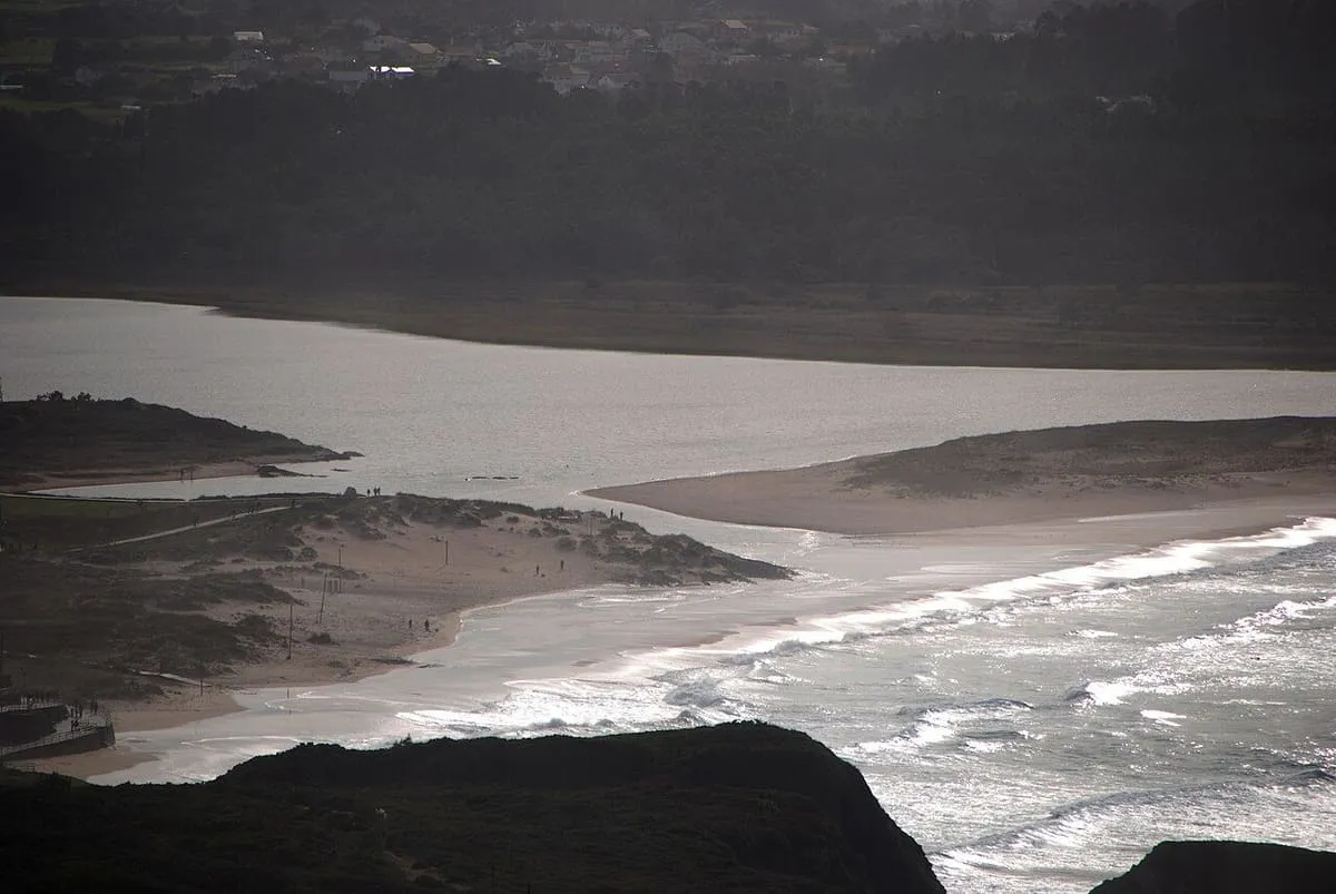 Canal de agua entre arena y rocas, donde la laguna se encuentra con el mar