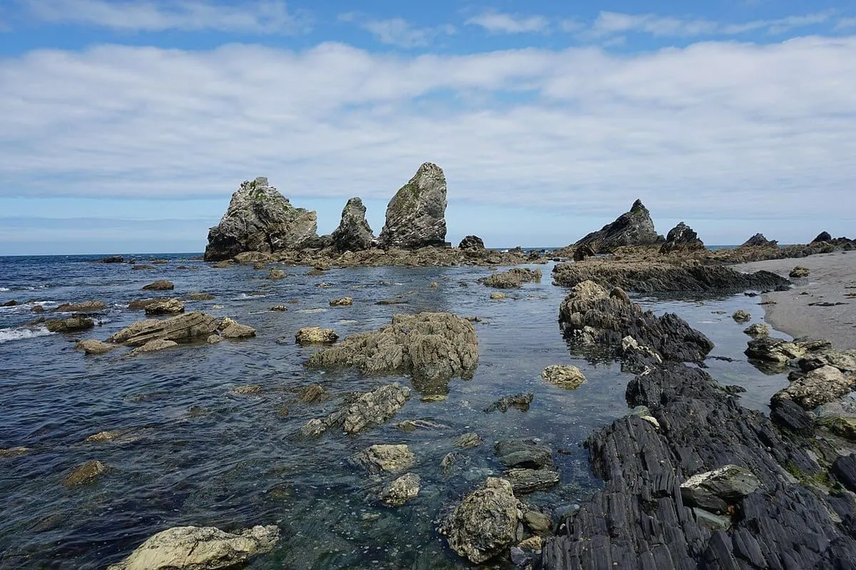 Agujas de roca oscura que salen del mar con la marea baja