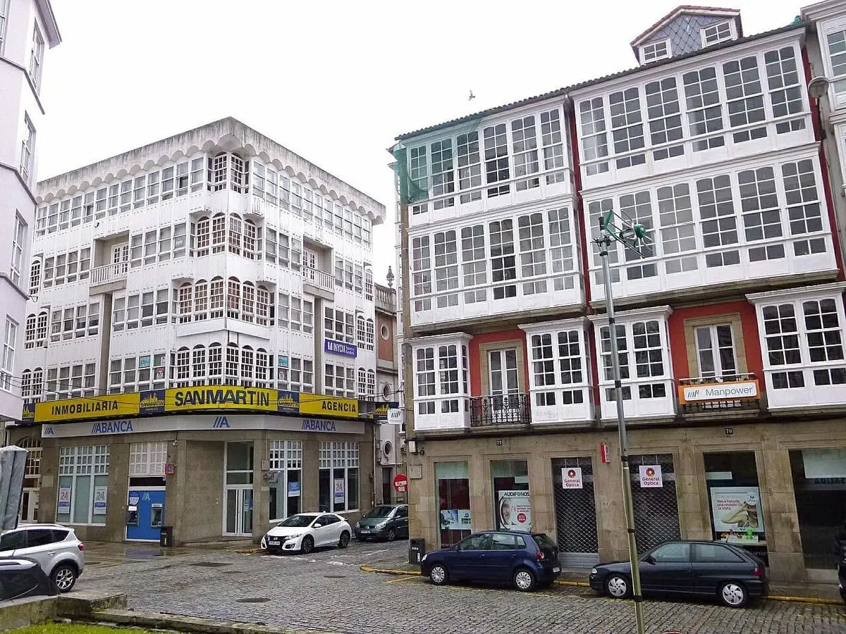 Edificios con galerías acristaladas de madera blanca en una esquina de la plaza de Armas