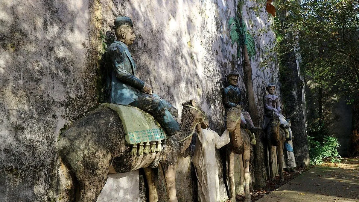 Relieve de figuras montadas en camellos sobre un muro, entre árboles