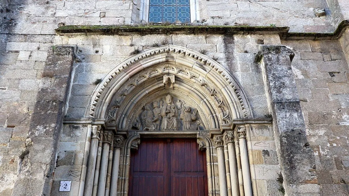 Portada gótica de arcos apuntados con arquivoltas y una puerta de madera