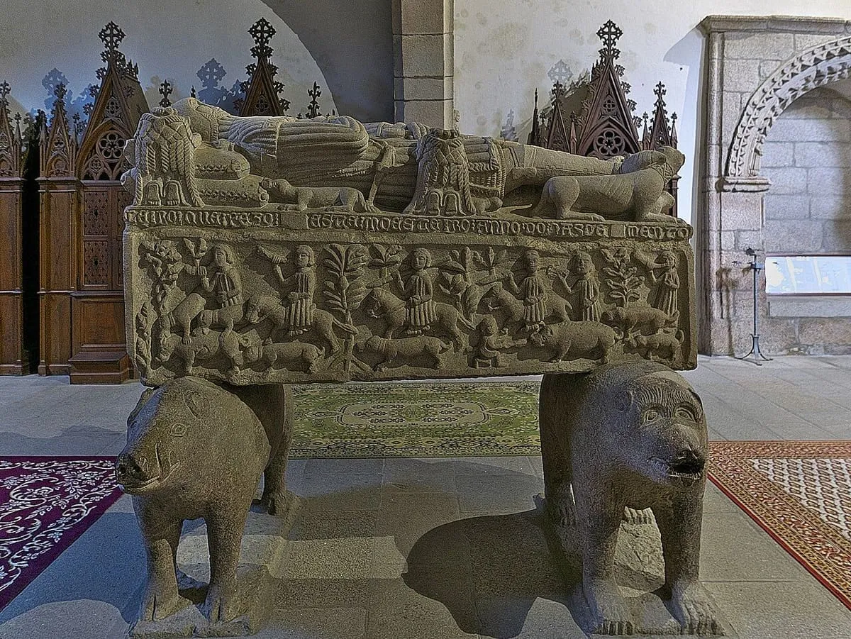 Sepulcro de piedra con la figura yacente de un caballero, sostenido por un oso y un jabalí