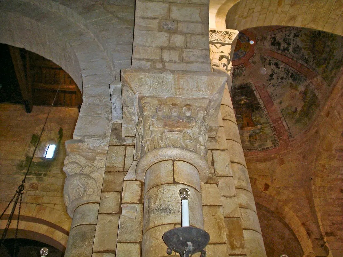 Interior de la iglesia con arcos de medio punto y muros de piedra