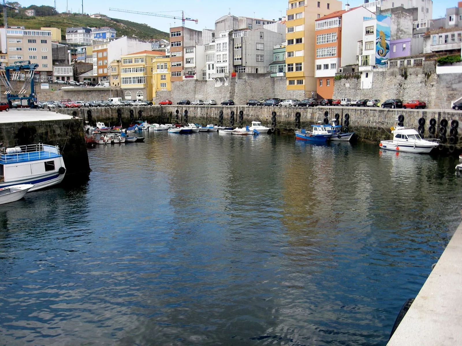 Puerto de Malpica con barcas de pesca y casas de colores sobre el muelle