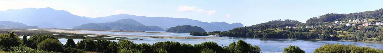 La ría de Ortigueira con una isla arbolada, marismas y montes al fondo
